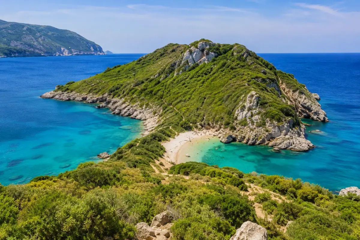 Twin turquoise coves surrounded by green cliffs on the Corfu coast