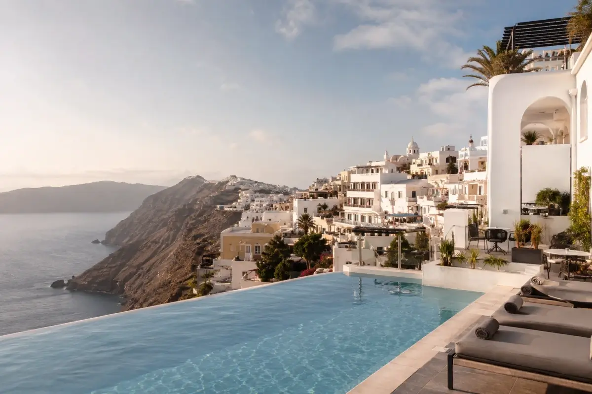 Fira hotel infinity pool overlooking Santorini’s caldera and cliffside town