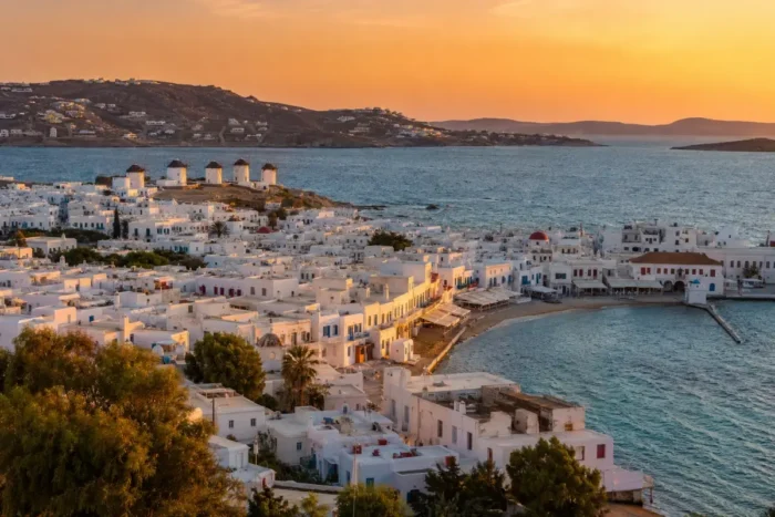 Sunset view over Mykonos Town, the waterfront, and the windmills