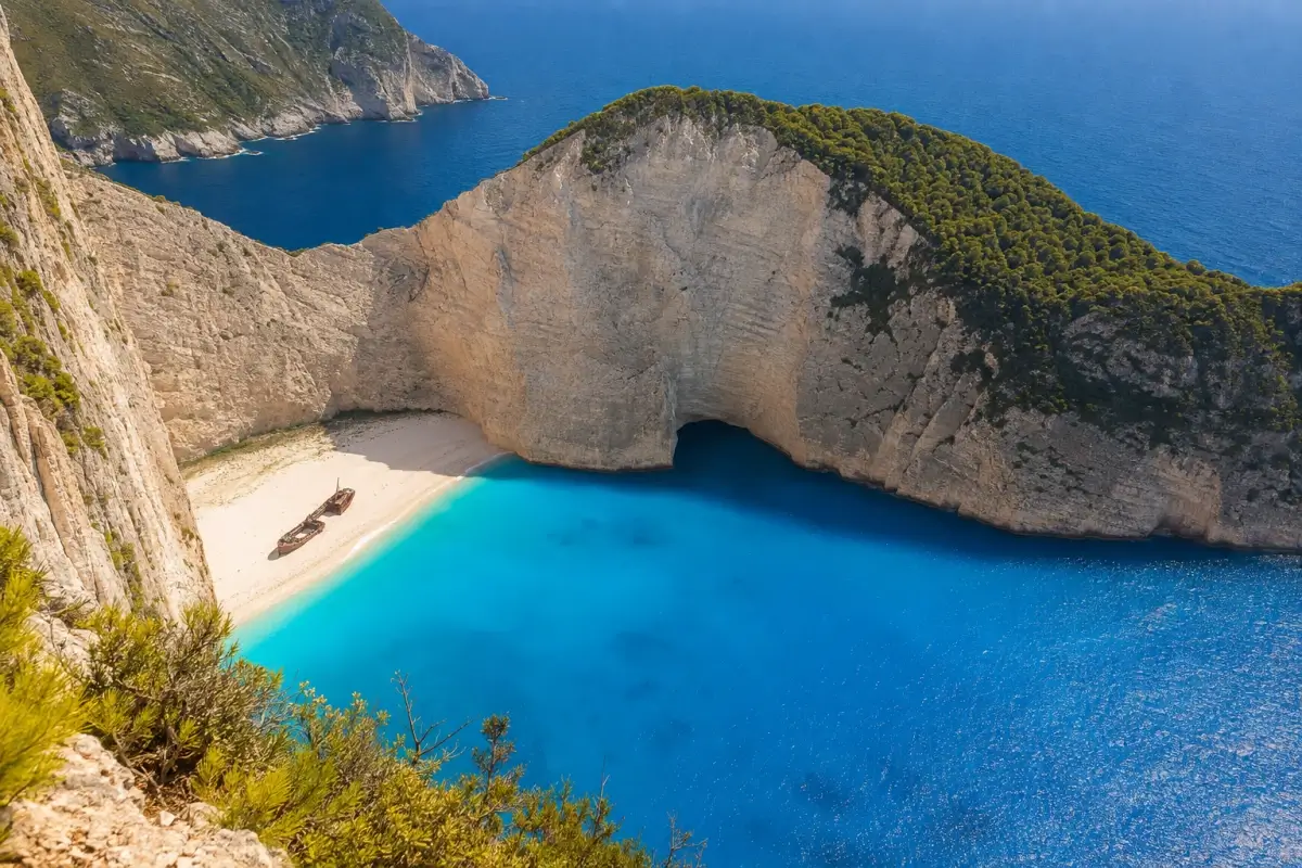 Navagio Beach and its shipwreck surrounded by limestone cliffs and blue Ionian water in Zakynthos