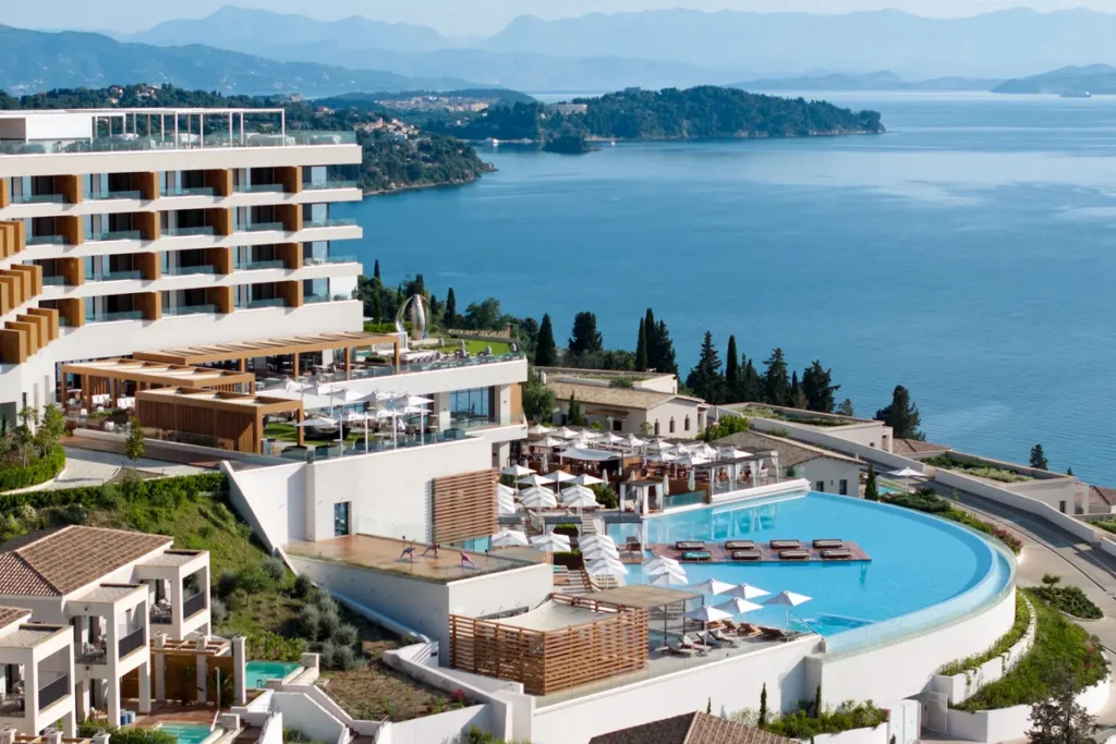 Angsana Corfu's curved pool and multi-level hotel buildings overlook the sea and coastline