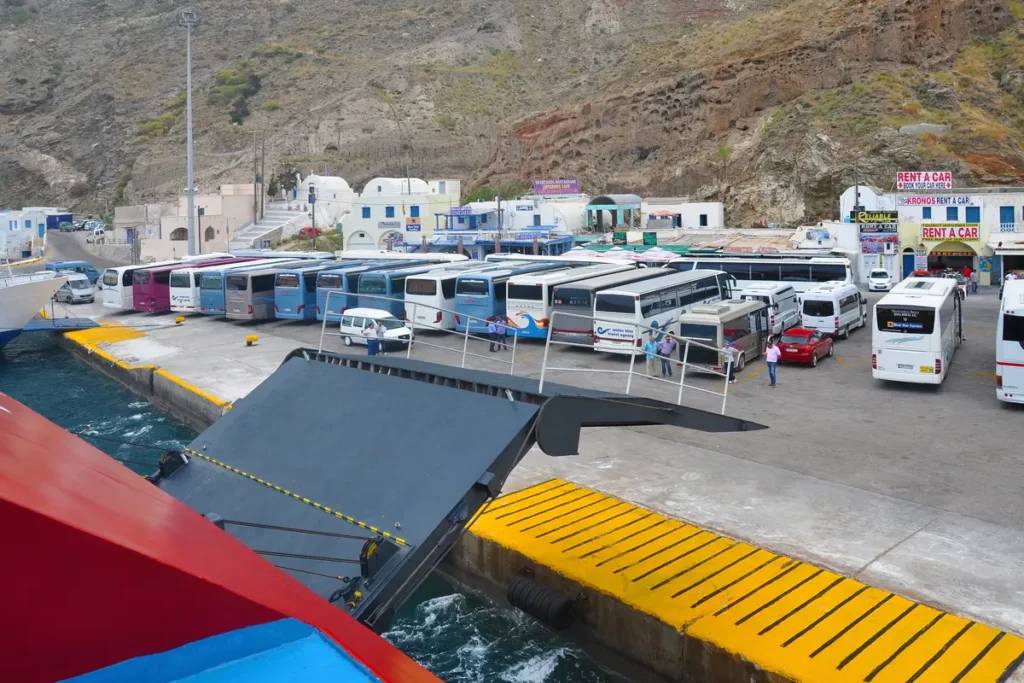 Coaches lined up beside a ferry loading ramp at Athinios port in Santorini.