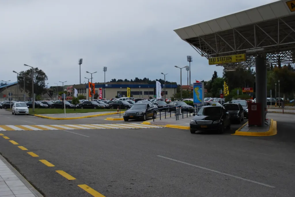 Cars and marked lanes outside the covered entrance to Corfu Airport