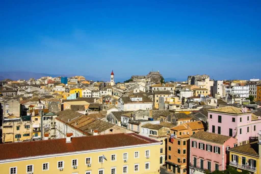 Terracotta roofs, pastel buildings and a church tower rise above Corfu Old Town