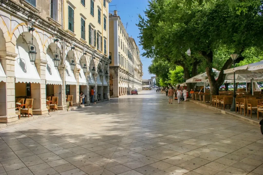Café tables and umbrellas line the paved walkway beside Liston's stone arcades