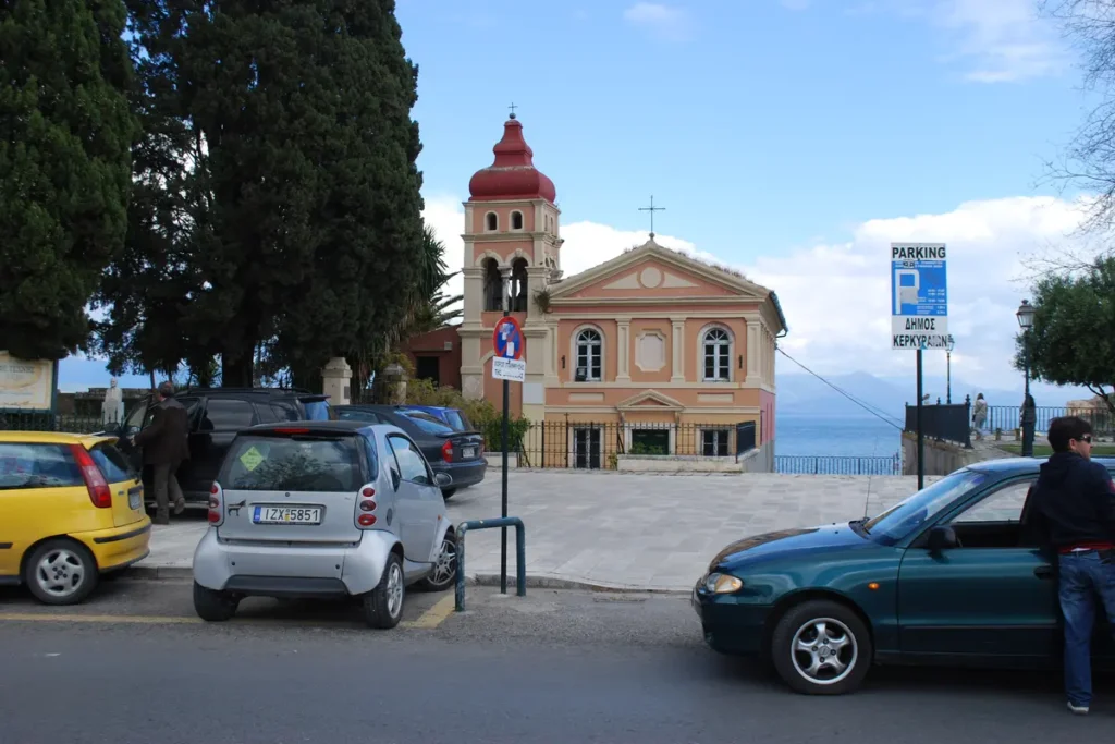 Compact cars parked beside the Panagia Mandrakina church in Corfu Town