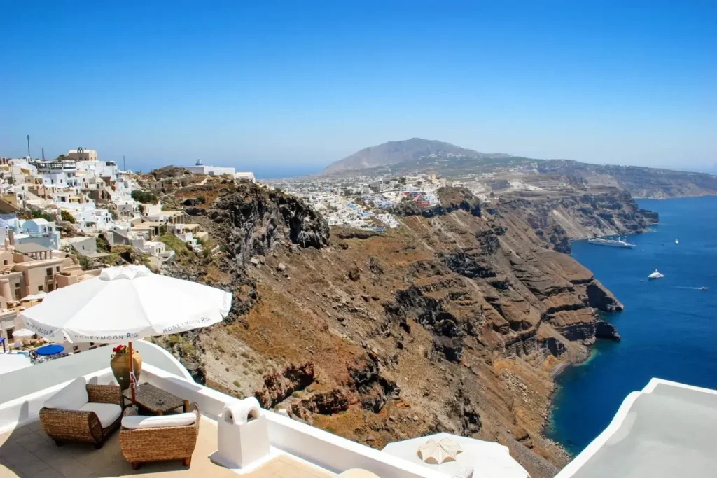 White terraces and buildings above steep volcanic cliffs in Imerovigli, with the sea below.