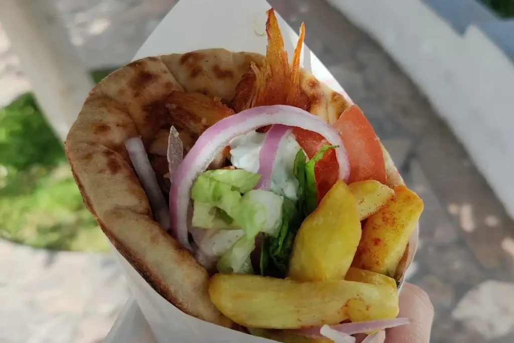 A pita wrap filled with meat, onion, tomato and fries from Lucky’s in Fira.