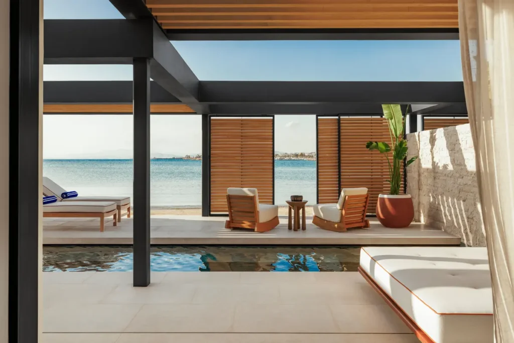 A shaded living area opens onto a private pool, wooden loungers and a sea-facing terrace at One&Only Aesthesis.