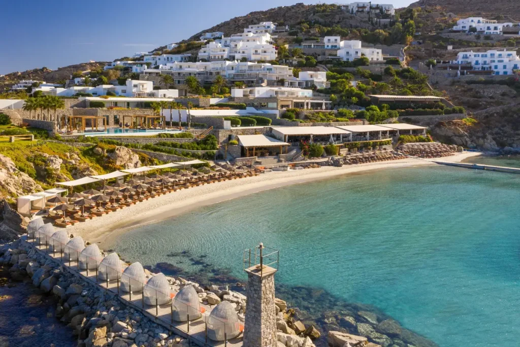 Rows of umbrellas on Santa Marina's sandy beach, with the resort rising behind the sheltered cove