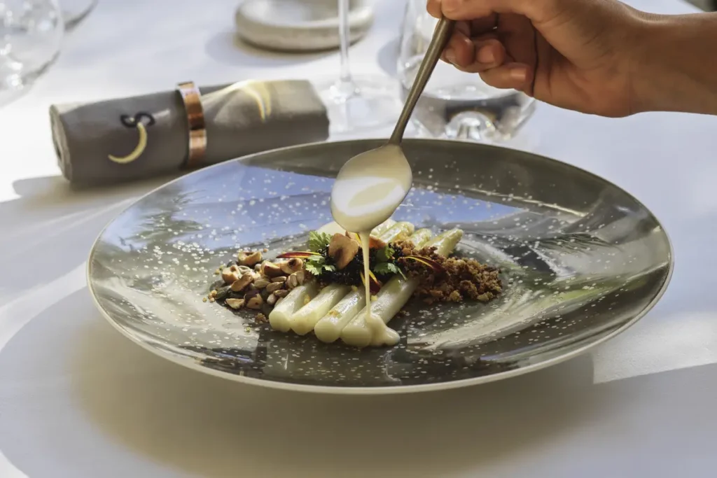 Sauce being poured around a carefully arranged dish at Selene in Santorini.