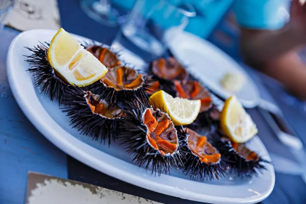 Opened sea urchins served with lemon wedges on a white plate at Spilia in Mykonos