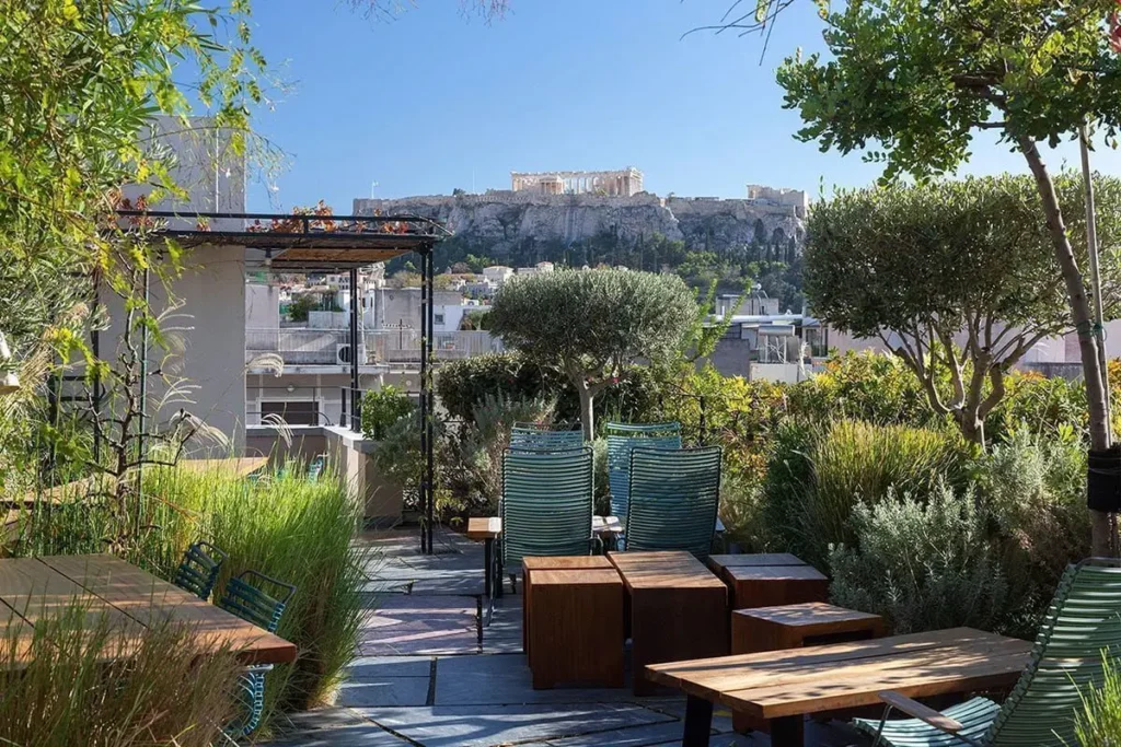 A path and seating areas surrounded by rooftop greenery at The Foundry, with the Acropolis in the distance.