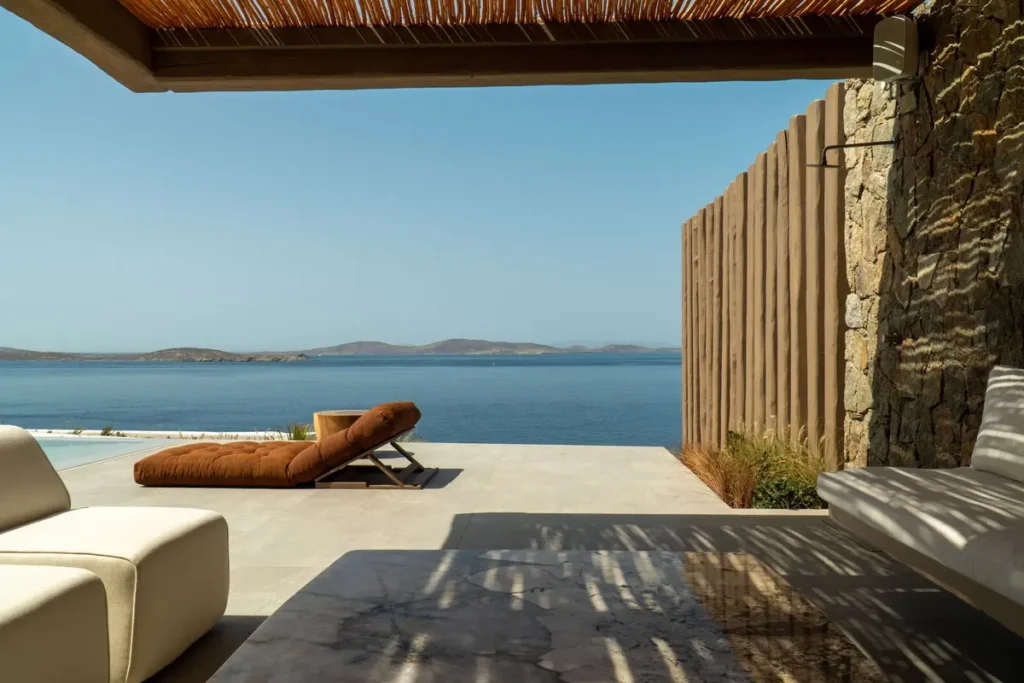 Shaded lounge terrace and a sculpted sun lounger facing the sea at Villa Charisma