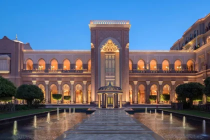 Illuminated arches and a central entrance above reflecting pools at Emirates Palace Mandarin Oriental, Abu Dhabi.