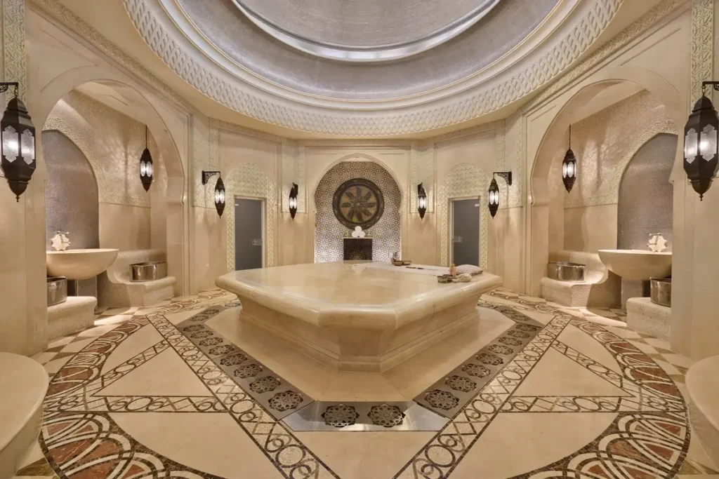 Central stone treatment platform, carved arches, and patterned floor in the hammam at Emirates Palace Mandarin Oriental, Abu Dhabi.
