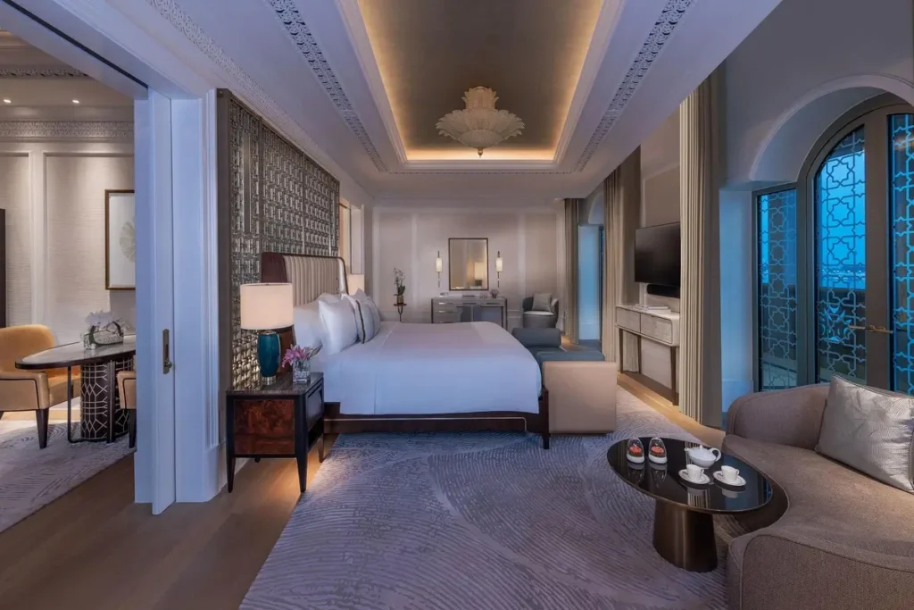 Bed, seating, and arched windows in the Panoramic Sea View Suite bedroom at Emirates Palace Mandarin Oriental, Abu Dhabi.