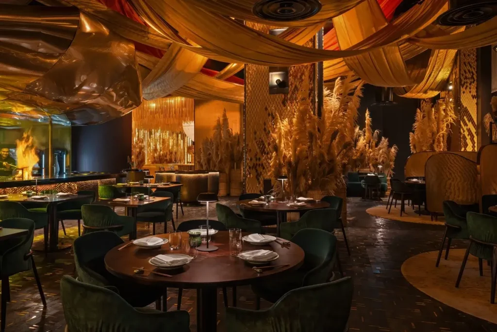 Set dining tables beneath draped fabric and warm lighting at Strawfire in Emirates Palace Mandarin Oriental, Abu Dhabi.