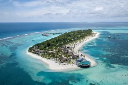 Aerial view of a palm-covered island surrounded by white beaches and turquoise water at Six Senses Kanuhura