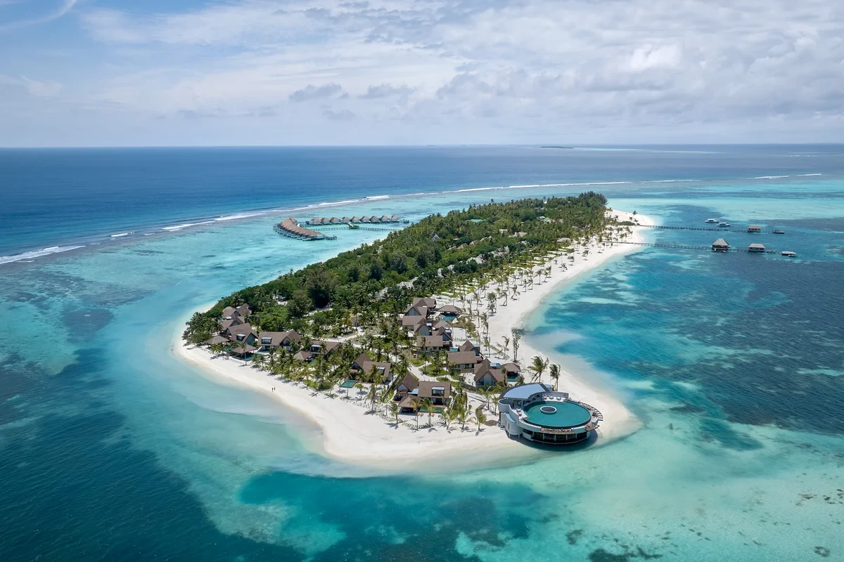 Aerial view of a palm-covered island surrounded by white beaches and turquoise water at Six Senses Kanuhura