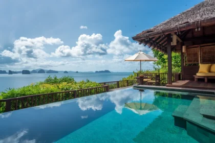 Private infinity pool beside a thatched villa overlooking distant limestone islands at Six Senses Yao Noi