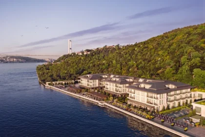 Mandarin Oriental Bosphorus, Istanbul stretches along the shoreline below a wooded hillside, with the strait and a distant bridge beyond.