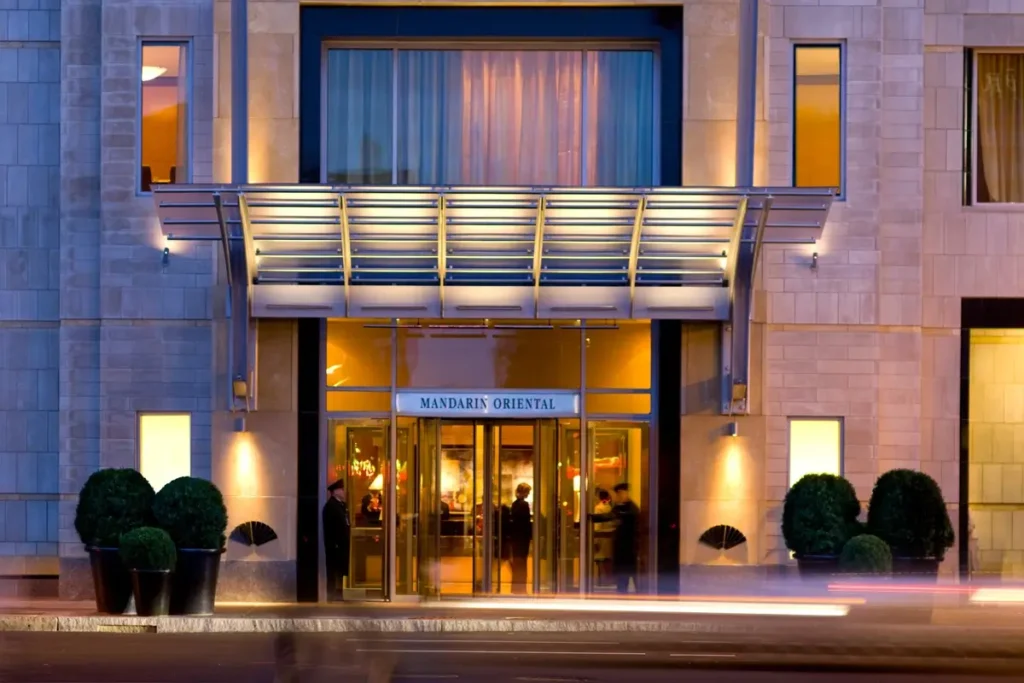 Illuminated entrance canopy, hotel signage, and stone facade at Mandarin Oriental, Boston on Boylston Street.