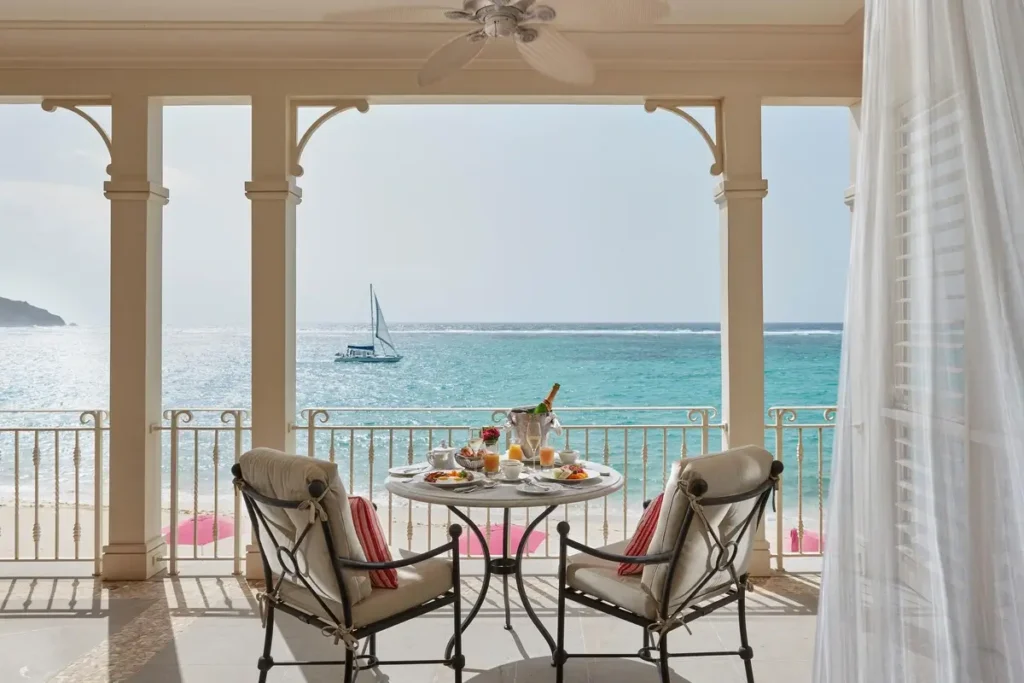 Two chairs and a breakfast table on an Oceanview Suite balcony overlooking the sea at Mandarin Oriental, Canouan.