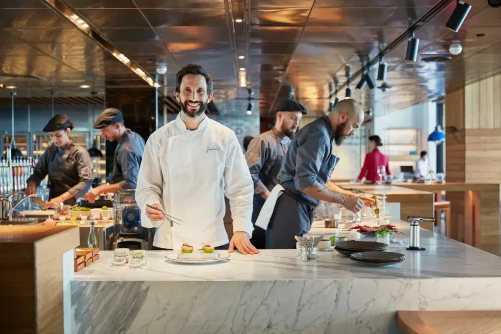 Chefs preparing dishes at the open kitchen counter in Tasca at Mandarin Oriental Jumeira.