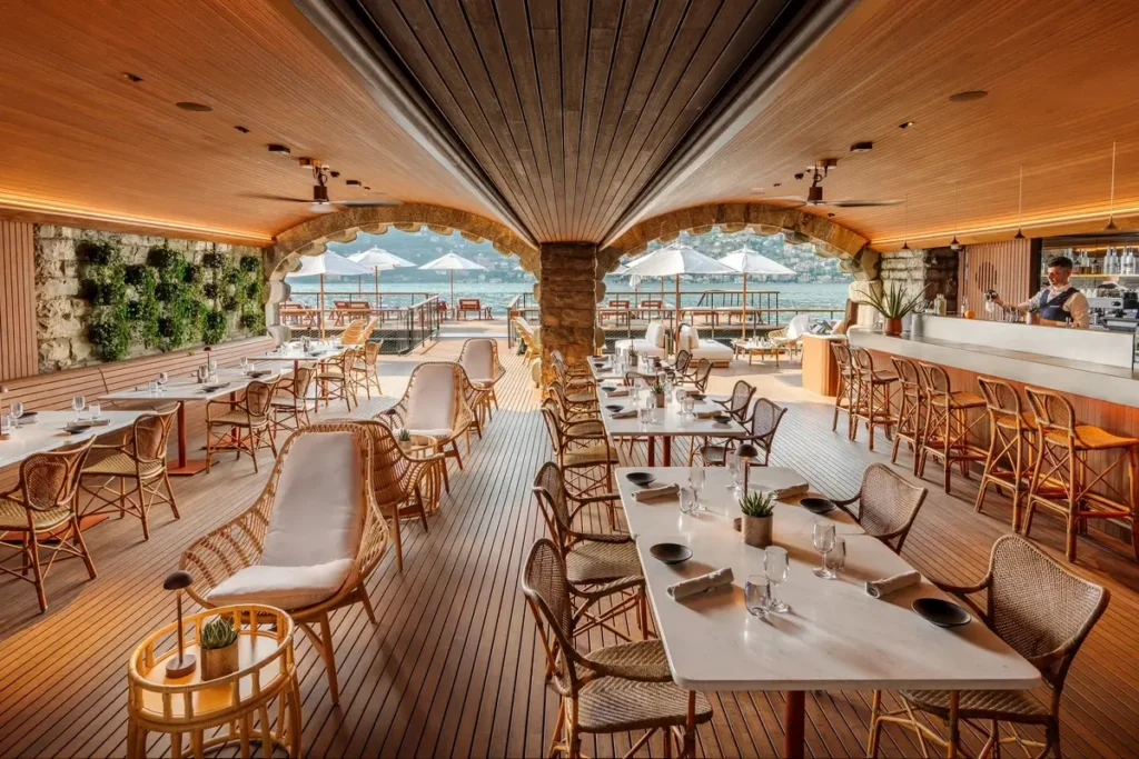 Set tables, woven chairs, a long bar, and a timber ceiling inside NAMI Cafe.