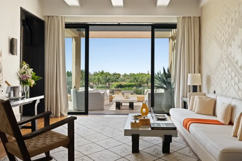 Sofa and chairs in an Atlas Suite living room opening onto a furnished terrace above the gardens.