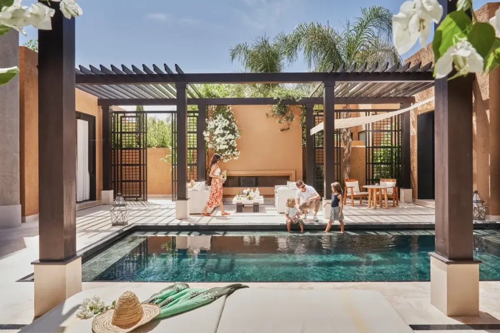 Private swimming pool, shaded seating, and guests in the enclosed courtyard of a Mandarin Pool Villa.