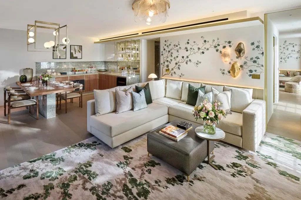 Pale sectional sofa, decorative wall panels, coffee tables, and a dining area in the Hanover Suite.