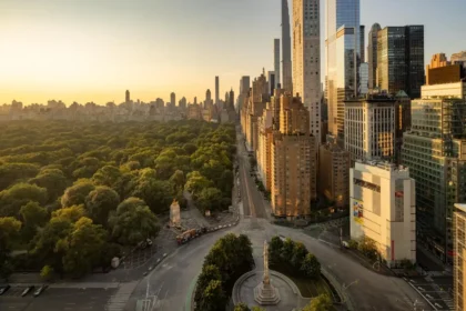 Elevated view across Columbus Circle, Central Park, and Manhattan towers in warm evening light.