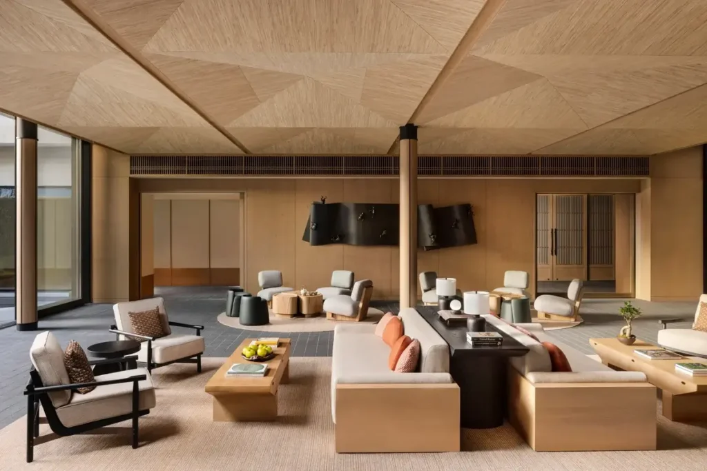Pale sofas, timber tables, and sculpted ceiling panels in the lobby lounge at Six Senses Kyoto