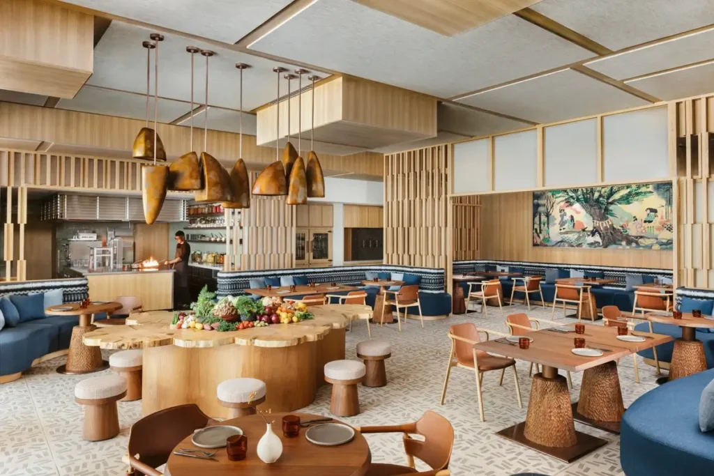Sekki dining room with blue banquettes, timber tables, hanging lights, and an open kitchen at Six Senses Kyoto