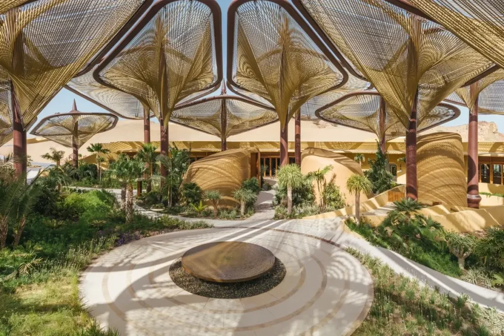 Branching columns and sculptural overhead canopies above planted paths at the Oasis at Six Senses Southern Dunes